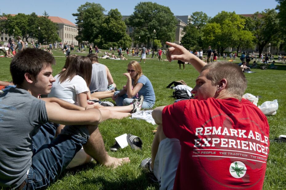 Students relax outside a residence hall on The Ohio State University campus, showcasing the vibrant community and top-ranked dorm life OSU is known for.